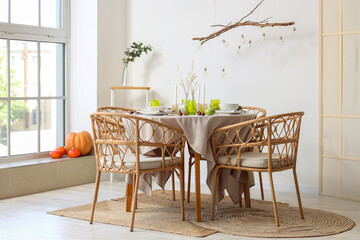 Autumn table setting decorated for Thanksgiving Day with pumpkins and chestnuts in light dining room
