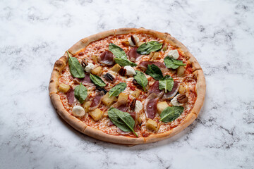 A beautifully crafted pizza emerges from a cozy European restaurant, garnished with savory meats, fresh spinach, and aromatic spices. The warm, inviting atmosphere complements the flavors