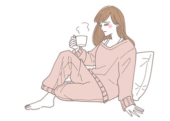 部屋で暖かい飲み物を飲みながらリラックスする女性