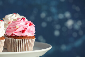 Stand with tasty cupcake for Valentine's Day on blurred blue background