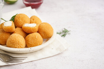 Plate with delicious fried mozzarella balls on light background, closeup