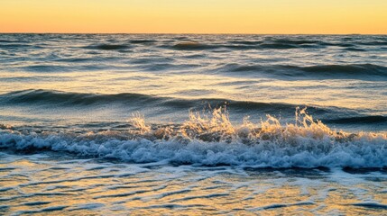 Naklejka premium A serene ocean view at sunset, with gentle waves reflecting golden hues on the water's surface.