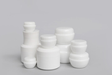 Composition with jars of cosmetic products on grey background