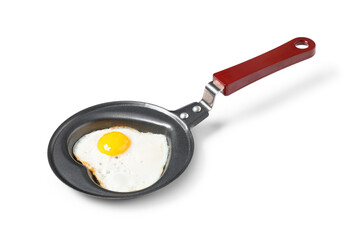 Frying pan with heart-shaped fried egg on white background