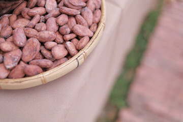 Raw organic cocoa beans are taken in a woven container.
