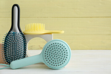 Hair brushes on white wooden background