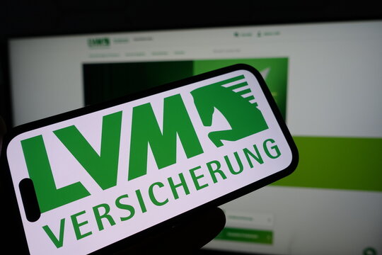 Kiel, SH, Germany March 19 2025: Smartphone with the logo of LVM Versicherung in front of a monitor showing their business website for insurance services