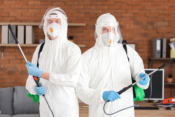 Professional workers with disinfectant in office