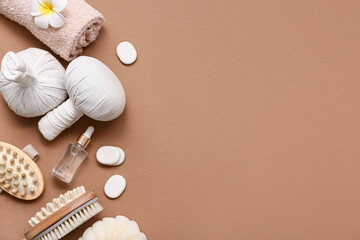 Composition with herbal bags, spa stones, massage body brushes and bottle of natural cosmetic product on brown background