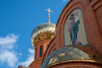 bottom view domes of christian church with crosses on blue sky background