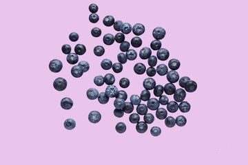 Flying sweet fresh blueberries on lilac background