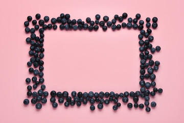Frame made of sweet fresh blueberries on pink background