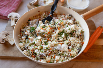 Vegetarian pan dish with basmati rice, feta cheese, mushrooms and carrots. Healthy homemade food