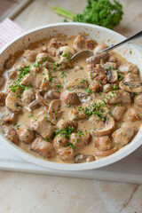 Bratwurst with mushroom cream sauce. Rustic german food in a frying pan