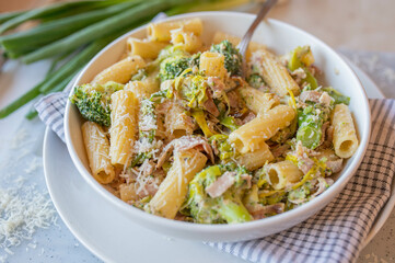 Pasta with leek, broccoli and ham in a delicious sour cream sauce on a plate