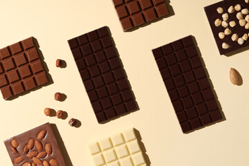 Composition with tasty chocolate bars and nuts on color background