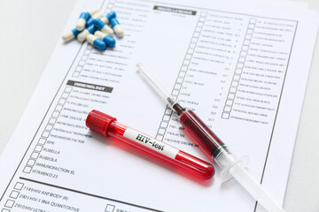 HIV blood test tube, syringe, pills and laboratory report form on grey background