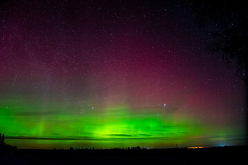 A stunning display of the Northern Lights with green and pink hues illuminating the night sky...