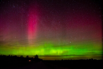 A stunning display of the Northern Lights with green and pink hues illuminating the night sky...