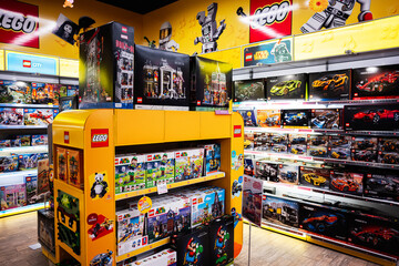 Naklejka premium Colorful LEGO store shelves showcasing various themed construction sets and iconic designs