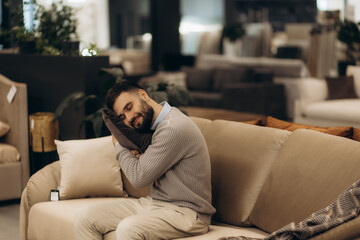 Man Relaxing on Sofa Testing Soft Pillow in Furniture Store