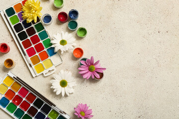 Paints and flowers on grey grunge background