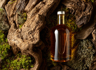 Bottle of strong alcoholic drink, old snags, and moss.