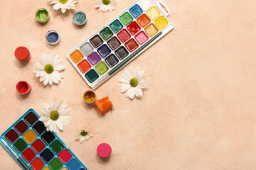 Paints and flowers on beige grunge background