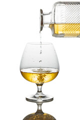 Cognac pouring into a snifter on a white background.