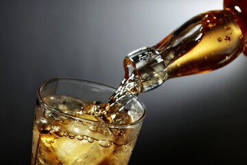 Whiskey being poured into glass with ice.