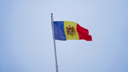 Moldovan flag waving against a gray sky during a chilly winter day in Chișinău