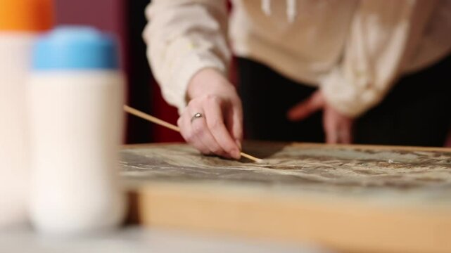 Restoration procedure of the painting. A restorer artist restores the colors in the painting. Female elegant hand holds brush in close-up. Cultural concept