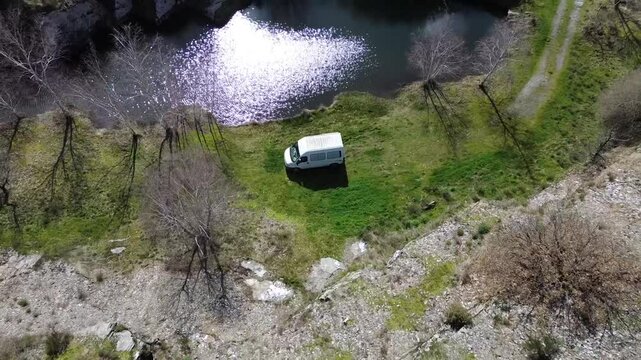Fourgon am&eacute;nag&eacute; au bord d'un lac dans la montagne noire en Occitanie, survol depuis un drone.