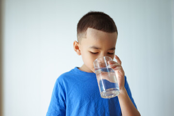kid drinking from a glass of water 
