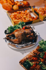 Happy young friends group having lunch at home. Asia family party eating pizza food and laughing enjoying meal while sitting at dining table together at house. Celebration holiday and togetherness.