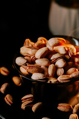 Pistachios in a dark bowl highlight delicious snack options for health-conscious individuals at home