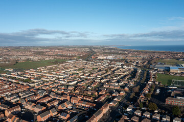 Obraz premium Aerial drone photo of the town of Hartlepool in the UK showing rows of terrace houses and homes and typical British suburban housing estates with the ocean in the background in the winter time