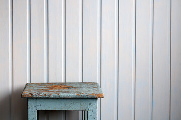 Old wooden stool standing in front of white wall. rural mockup