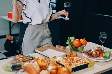Asian office colleagues and friends enjoy a daytime BBQ with pizza and beer, celebrating Halloween and cheering for their favorite soccer team, creating a lively atmosphere filled with joy.