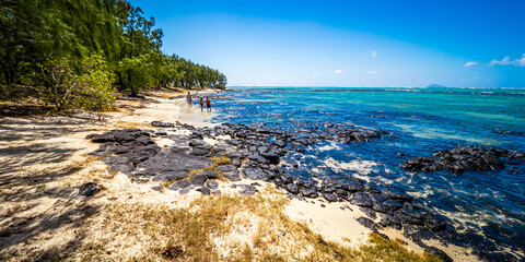 Picturesque view of mother and two children wading through the shallow crystal clear water, exploring the exotic island of L'îlot Bernache, Mauritius © schusterbauer.com