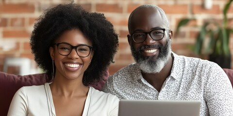 Happy Black Couple Smiling While Using Laptop on Sofa at Home, Enjoying Technology Together