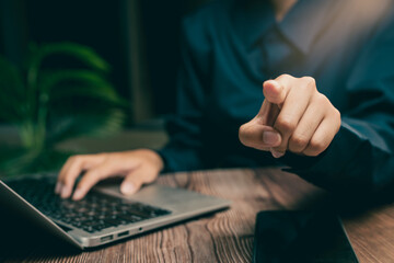 Business Professional Engaging with Laptop While Pointing Finger Towards Camera in Modern Workspace, Business concept
