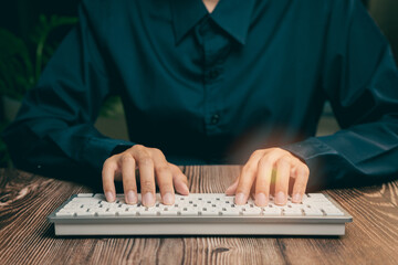 Close-Up of Hands Typing on a White Keyboard in a Dark Environment with Soft Lighting Effect,...