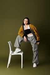 Stylish young woman showcasing trendy street fashion in an artistic indoor setting