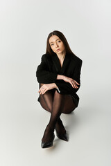 Young woman showcasing elegant style while sitting gracefully in a modern indoor space