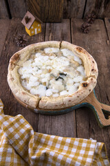 Neapolitan pizza 4 cheeses on wooden table