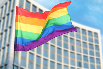 LGBT flag fluttering against building outdoors, low angle view