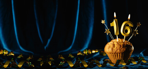 Coming age party 16th birthday. chocolate cupcake with number sixteen candle on velvet blue background. Banner