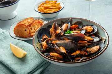Mussels with French fries, toasted bread, and lemon. Moules frites, Mediterranean diet, seafood dish