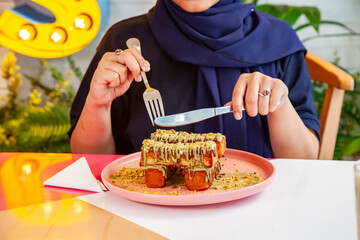 Female enjoying french toast kunafa style served with milk shakes at a fancy cafe restaurant.  